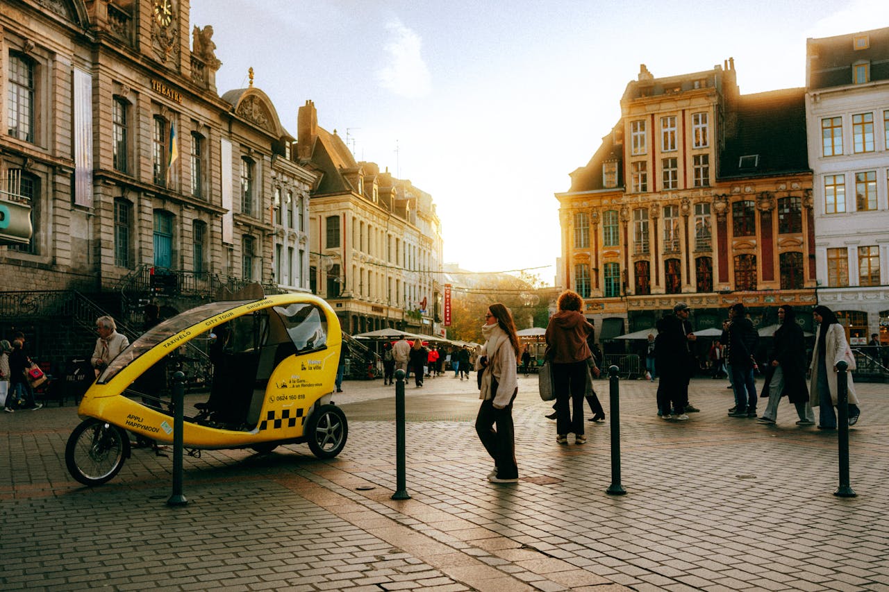 Sunset view of a vibrant city square with historic buildings and a yellow rickshaw.