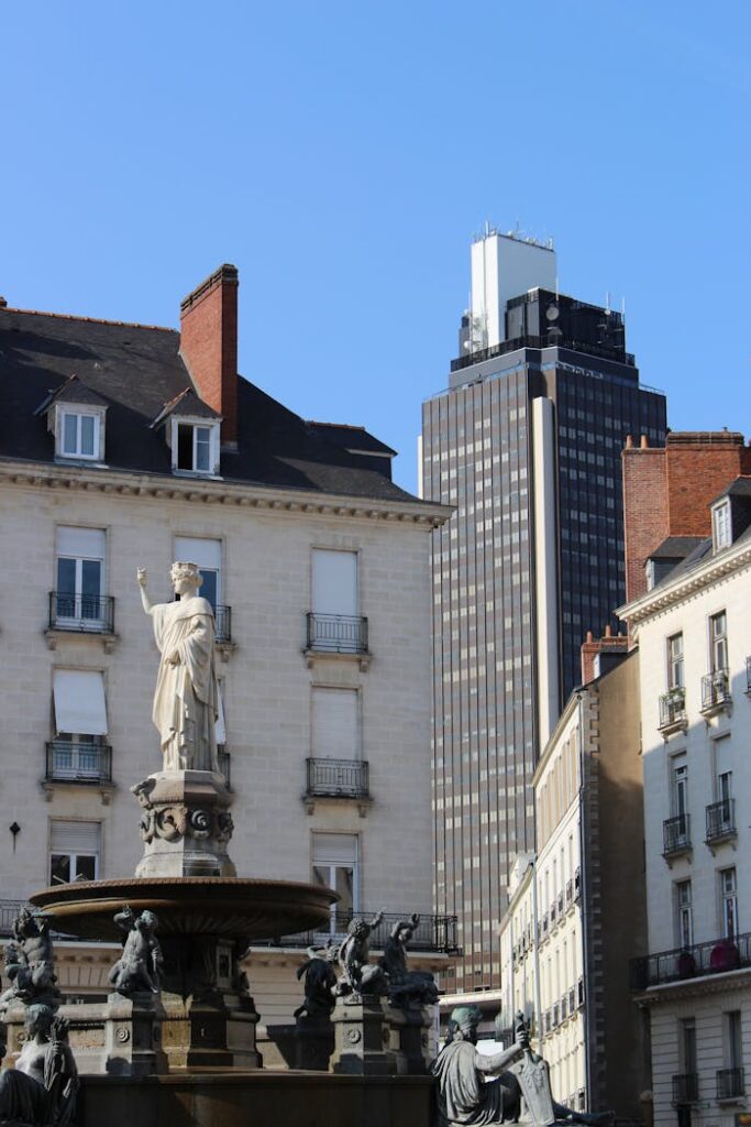 pexels-photo-6030868 Statue and fountain in front of historical buildings and modern skyscraper in sunlight.