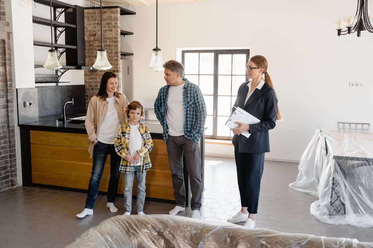 pexels-photo-7415022 Family exploring a newly purchased home interior with real estate agent.
